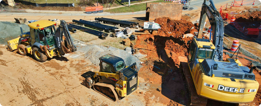 Site preparation and excavation work in North Carolina, showcasing heavy machinery and utility installation by licensed general contractors.